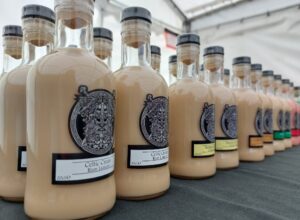 image lined up bottles containing creamy latte coloured liquid, viking image on labels. bottles containing different flavoured rum liqueurs.