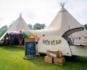Image of tipple on taps vintage teardrop trailer bar in cream and brown colour set in front of a double tipi marquee