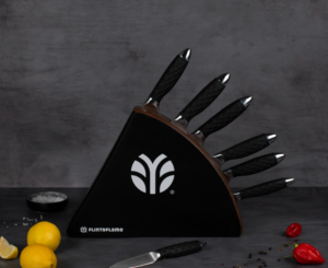 image of six carbon steel kitchen knives with black handle in a black knife holder.