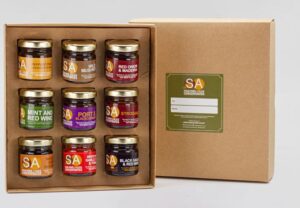 image of 9 small jars of assorted sauce concentrate in presentation box