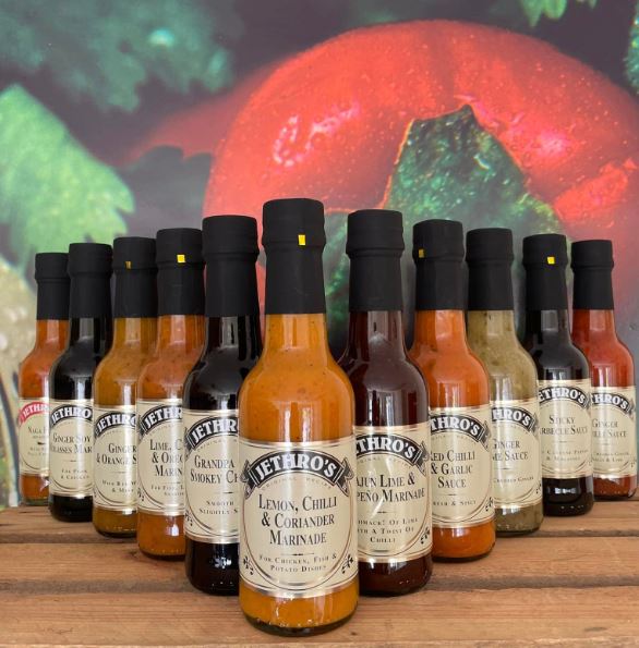 image of several different bottles of marinade in a range of flavours.diffrent shades of oranges, browns and pale greens.