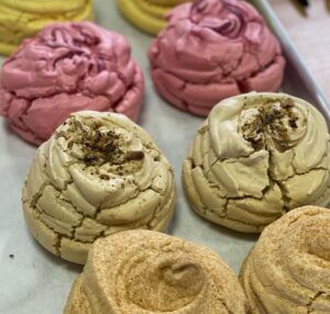 image of light , fluffy meringues in various flavours and colours, light brown, green pink and yellow.
