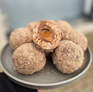 image of chocolate scotch eggs with rice crispy surrounding and caramel egg centre and powdery chocolate on the outer layer.